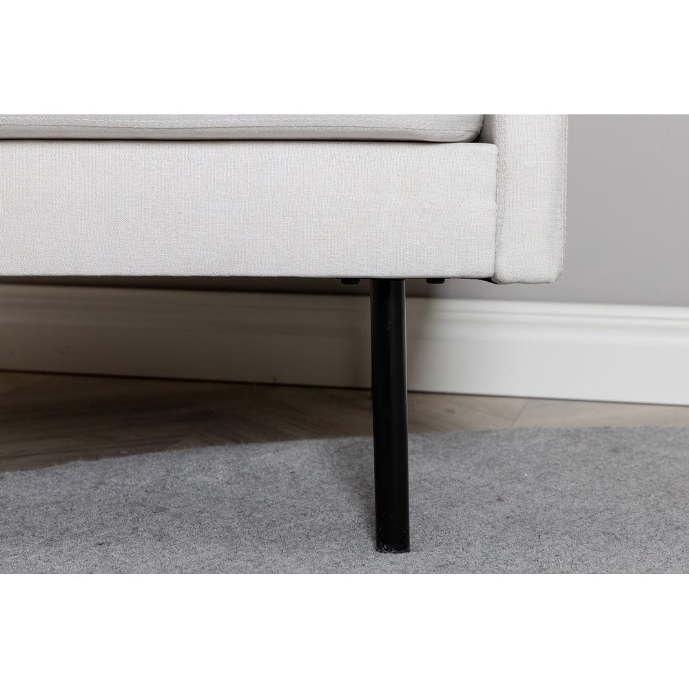 Närbild på Zoom ljusbeige fåtöljs svarta metallben och undre sitskant